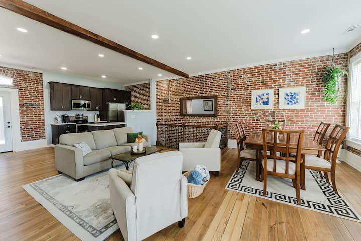 Exposed brick living room with a private deck overlooking the Gateway Arch in downtown St. Louis